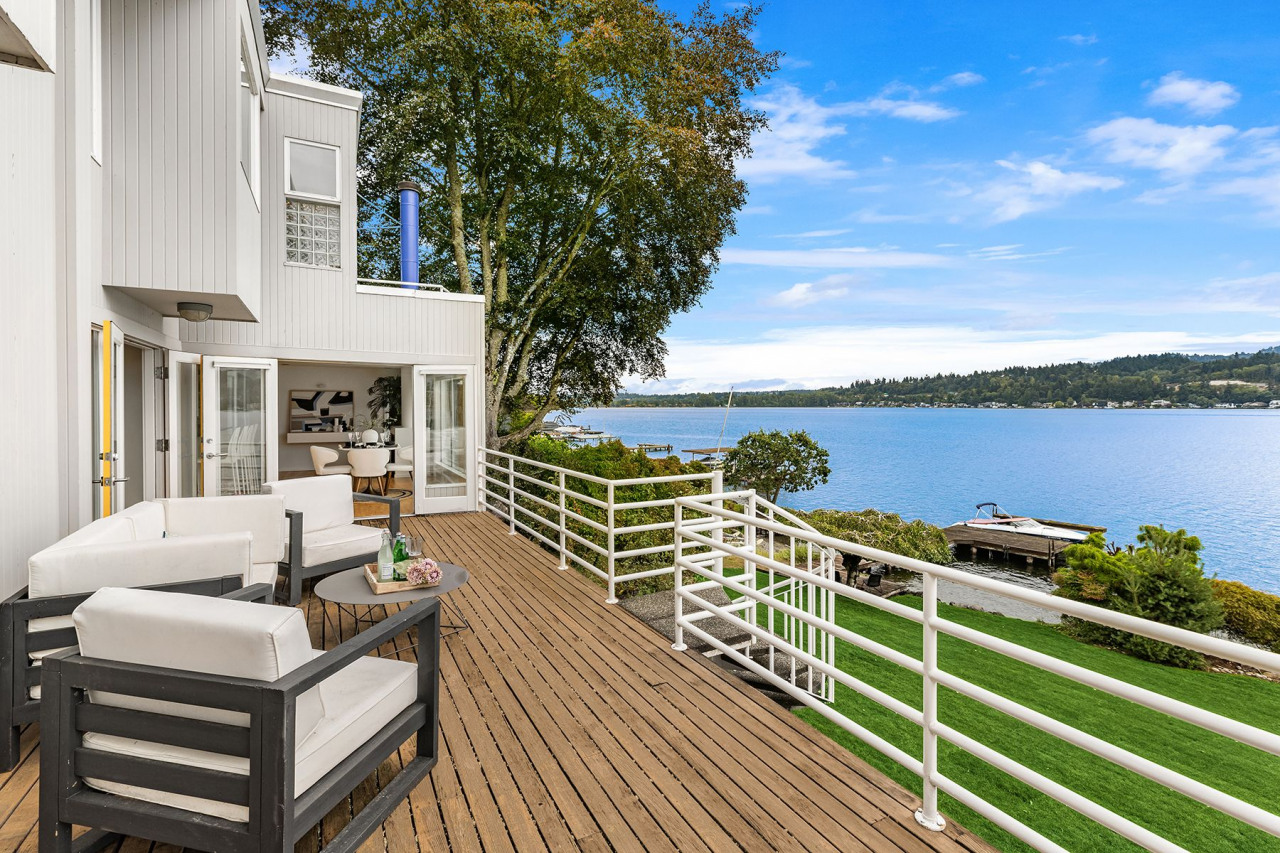 An expansive deck opens up to the shimmering water.