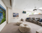 The room offers direct access to the deck and jacuzzi, as well as a Sub-Zero 18" integrated wine refrigerator, a 36" Sub-Zero fridge with two-drawer freezer and ice maker & W/D