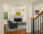 A wood burning fireplace anchors the perfectly proportioned living room.
