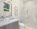 Ensuite bathroom features a floor-to-ceiling tiled shower stall with a built-in niche for storage.