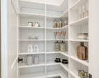 Walk-In Pantry with ample built-in shelving provides extensive storage for all your kitchen essentials.