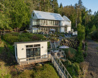 A garden path leads to the private studio, where French doors open to its own wraparound deck, fronting 82 feet of private, pristine shoreline.