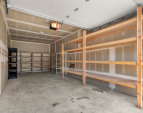 Spacious garage with built in shelving and storage potential - perfect for a boat