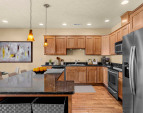Gourmet kitchen with warm wood cabinetry, full appliance suite, and ample counter space