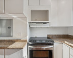 Nice bright kitchen with tall white cabinets and updated granite counters.