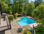The oversized sliding door seamlessly connects indoor and outdoor living, opening to a spacious deck that overlooks your private oasis, perfect for relaxing or entertaining.