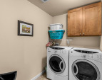Efficient laundry room with storage cabinetry and built in shelving