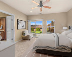 Tranquil primary bedroom with generous layout and large windows for natural light