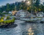 An idyllic waterfront lifestyle and setting with panoramic 240+ degree views, a sandy beach area, and a boat ramp!