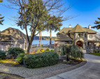 Circular drive, gorgeous landscaping, and water views in all directions!