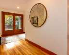 The foyer with French doors and white oak floors. There is a coat closet and powder room upon entry on the left.
