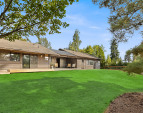 This is a view of the backyard showing a large lawn (it is now seasonally brown). The backyard is fenced.
