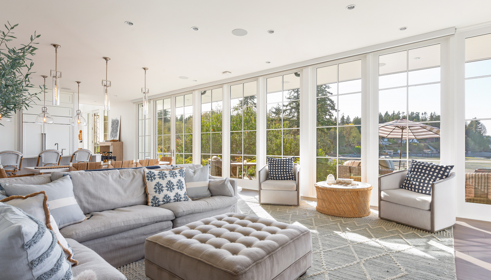 The main floor dining and living rooms flow into outdoor, resort-style areas featuring a covered patio, deck, hot tub, and lawn.