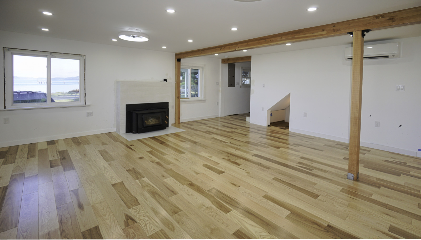 Living room with wood stove and spectacular views. doorway leads to the stairway up and the to the back entry near the driveway.