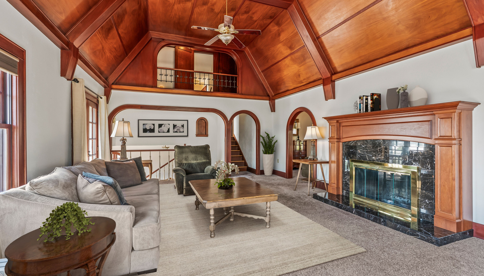 Balcony off the attic looks out on the mahogany vaulted ceilings and cozy wood-burning fireplace. Note partial virtual staging