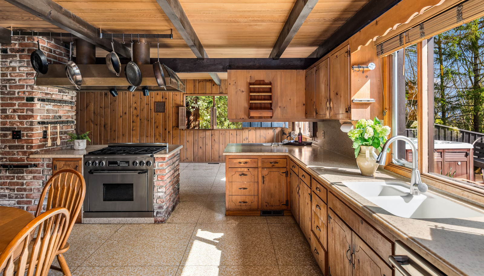 The kitchen is bathed in natural light, seamlessly flowing into the living space and featuring elegant terrazzo floors for a stylish and timeless touch.