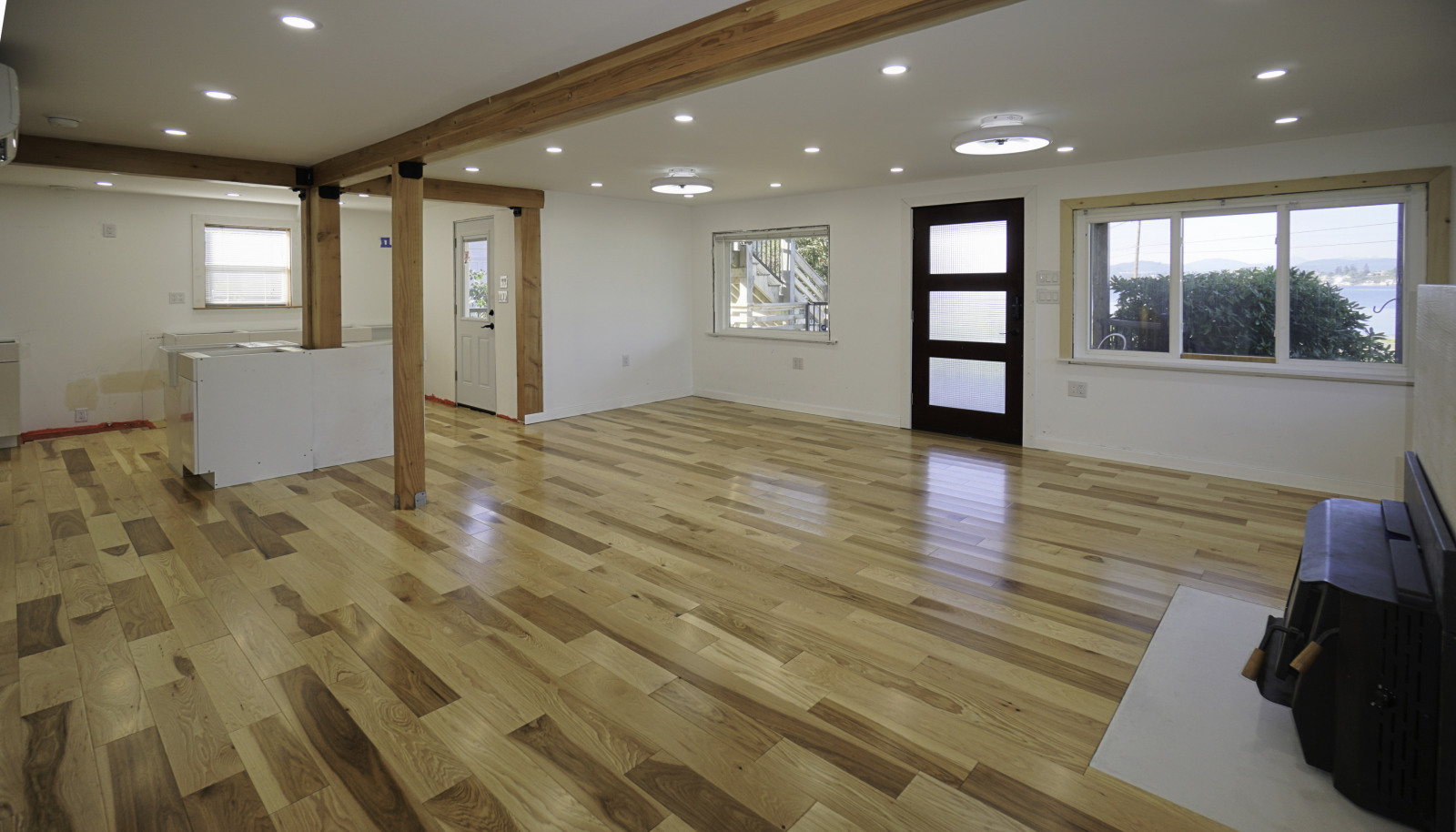 Main floor flooring and kitchen installation ongoing to the left.