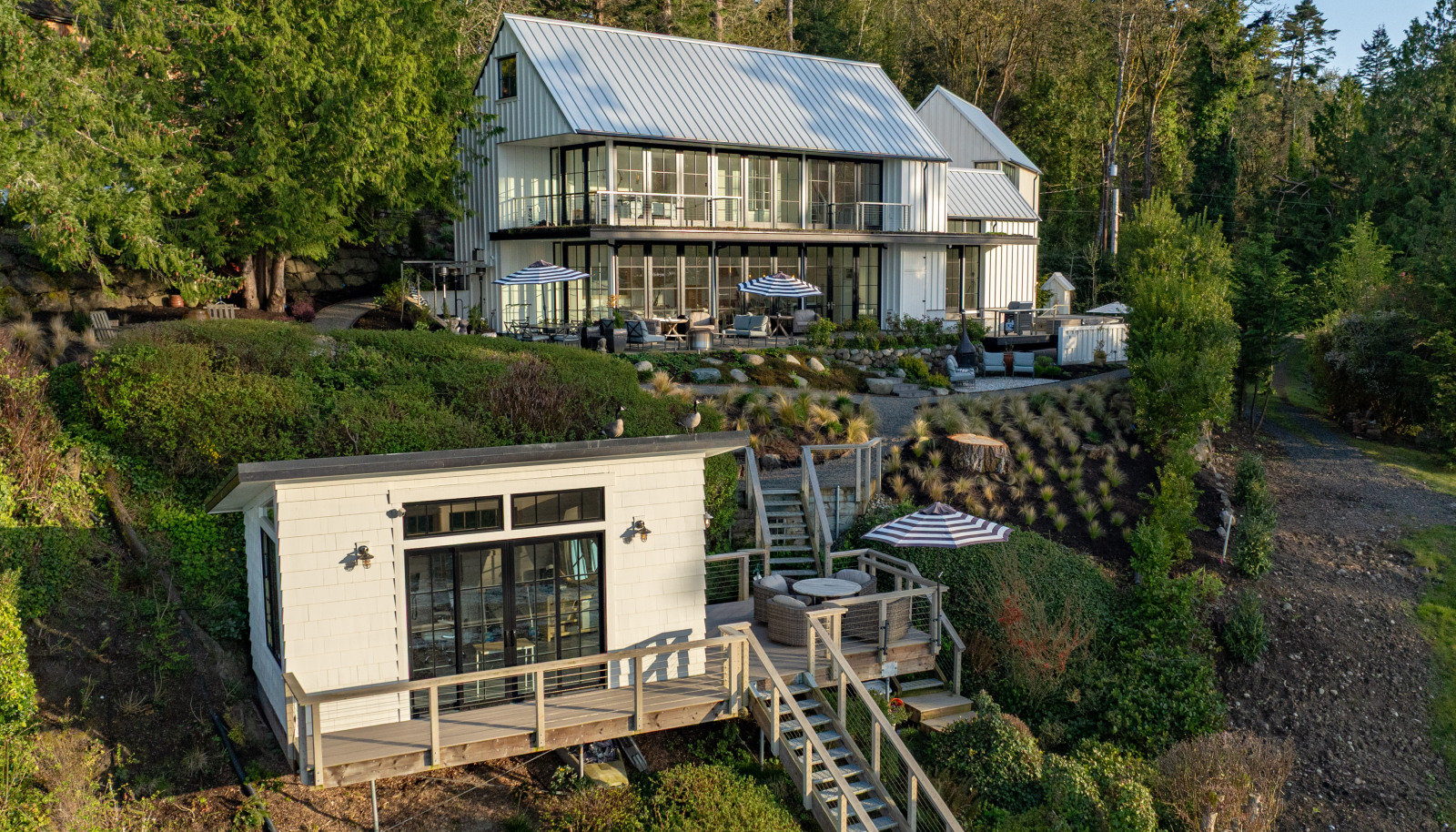 A garden path leads to the private studio, where French doors open to its own wraparound deck, fronting 82 feet of private, pristine shoreline.