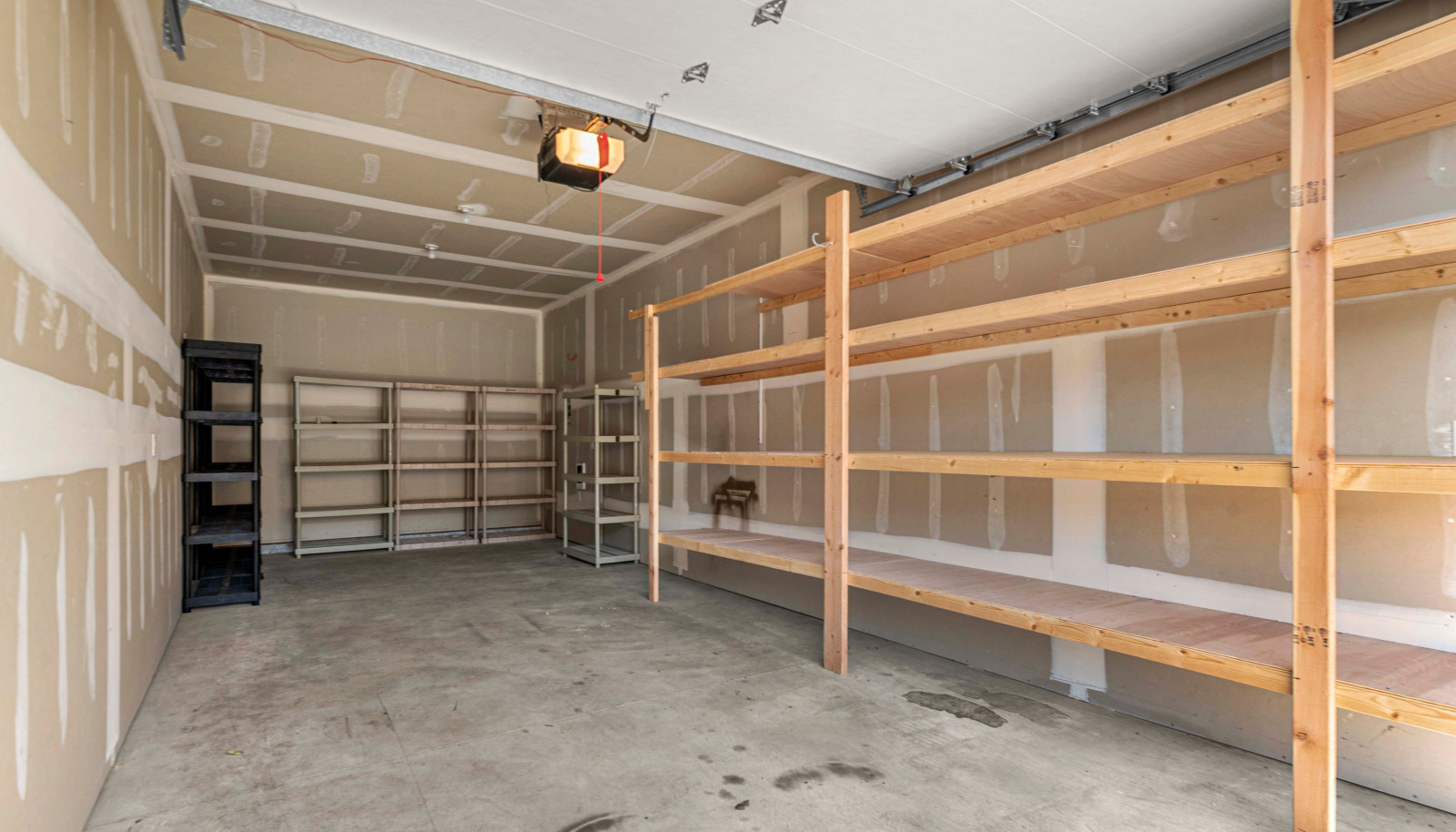 Spacious garage with built in shelving and storage potential - perfect for a boat