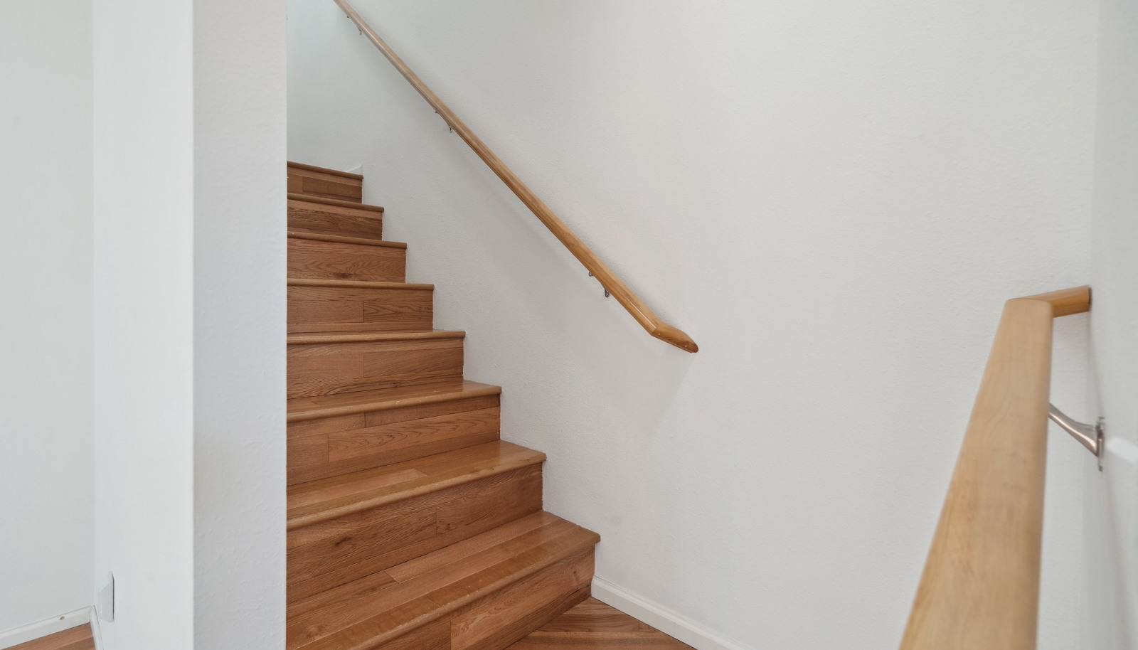 Wood stairs lead to the second level bedrooms and primary suite.