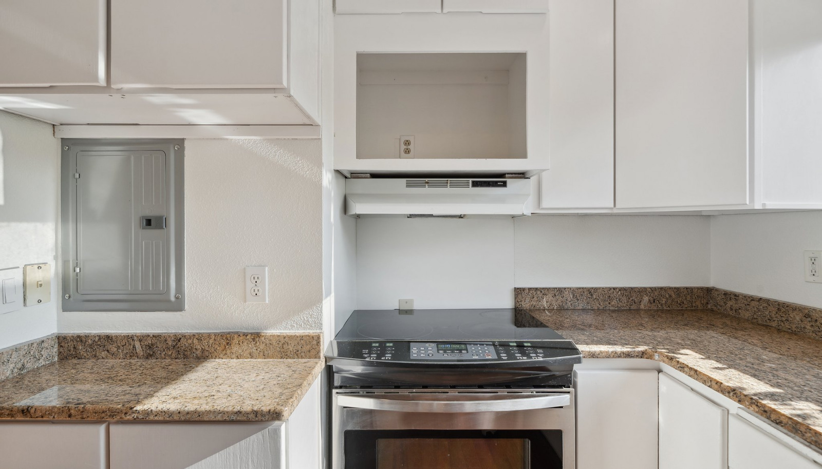 Nice bright kitchen with tall white cabinets and updated granite counters.
