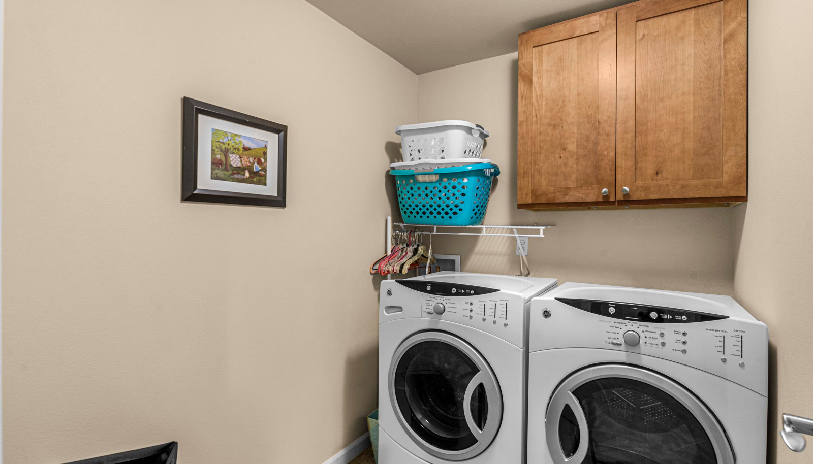 Efficient laundry room with storage cabinetry and built in shelving