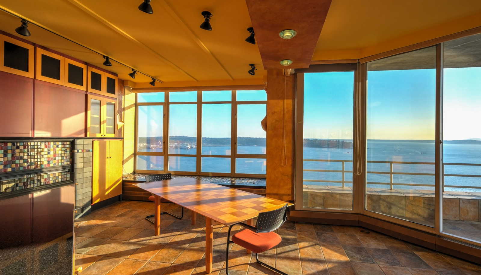 Open kitchen features spectacular water and mountain views, built-in window seat in bay window; floor to ceiling sliding door leading to a covered view terrace
