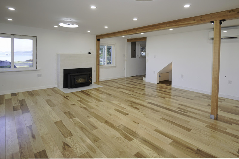 Living room with wood stove and spectacular views. doorway leads to the stairway up and the to the back entry near the driveway.