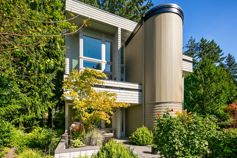 The home is surrounded by lush gardens and enjoys a sunny SW exposure, with two upper balconies and a large patio.