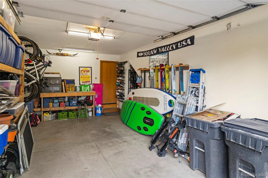 Garage area with storage shelves, bike hooks and work bench.