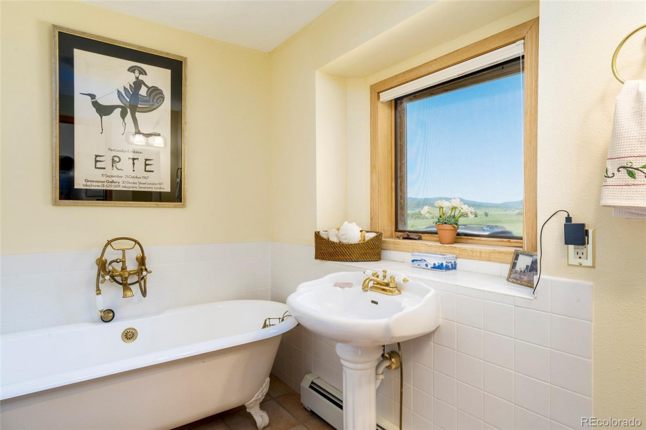 A full bath off of the main level office suite has a clawfoot tub.