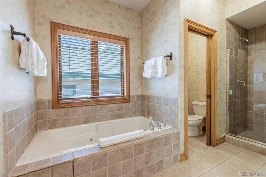 Large primary bathroom with walk in closet and soaker tub.