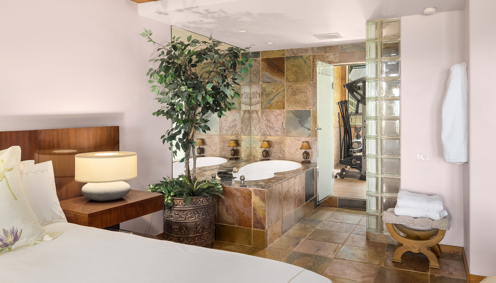 Primary bedroom #1 spa like bathroom with soaking tub, walk-in-shower, and direct access to the gym and massage room.